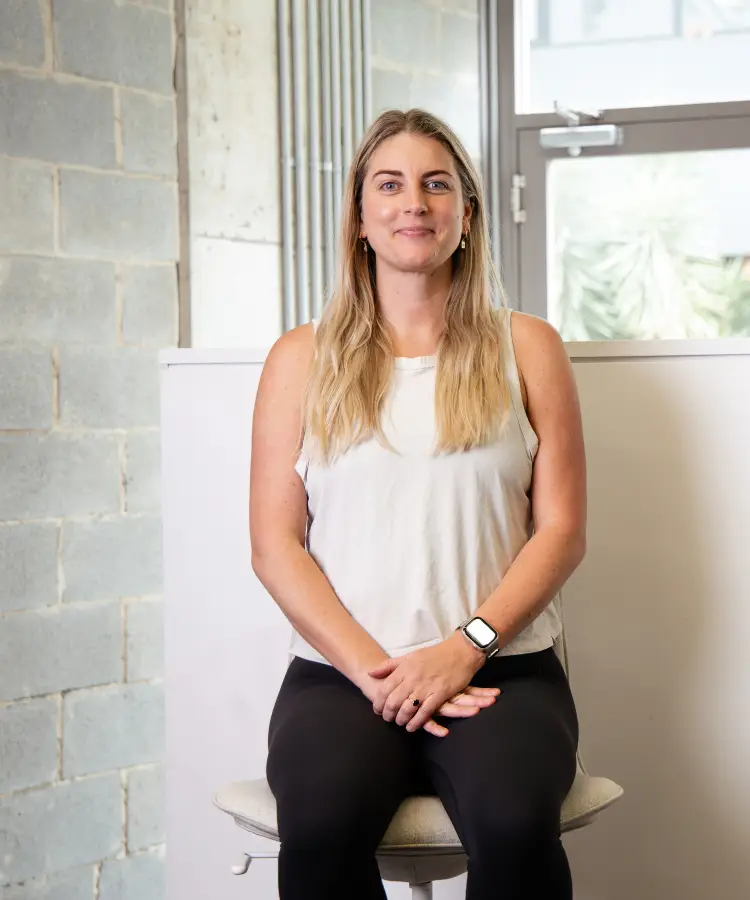 Alex Renkert, Business Development Manager, sits comfortably on a chair with a welcoming smile