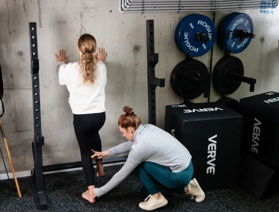 Claire Rees, Sports and Exercise Physiotherapist, helping a young patient with her posture